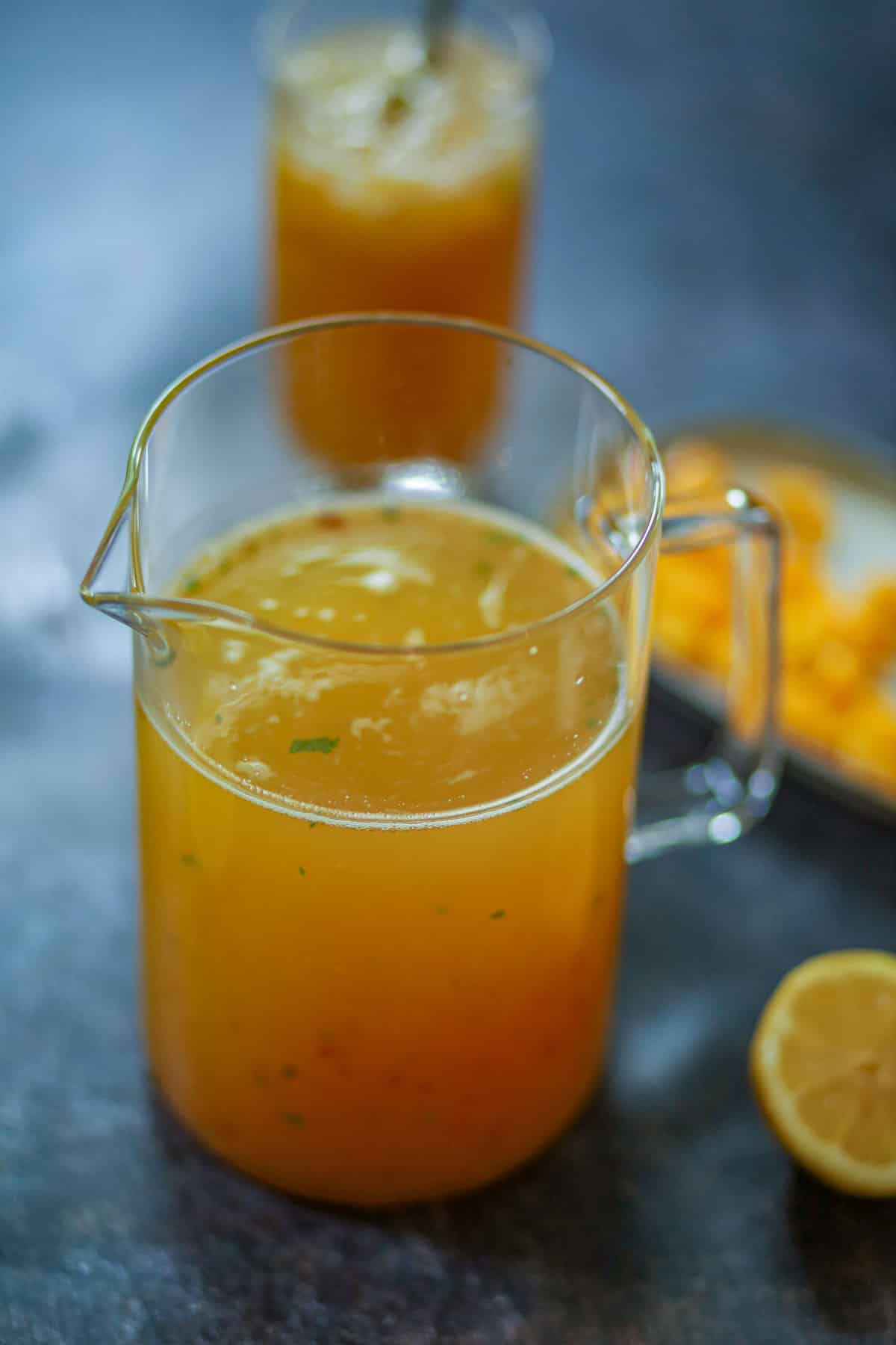 Homemade peach mango iced tea in a glass pitcher.
