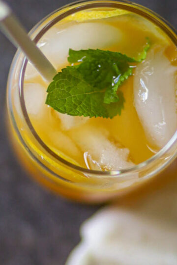 Overhead view of peach mango iced tea with ice and mint.