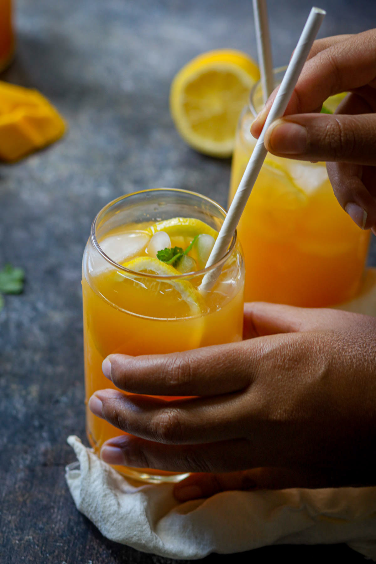 Peach mango iced tea being stirred before serving.