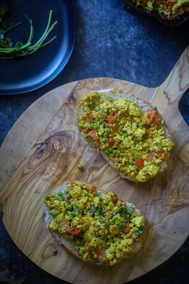 Breakfast bun with tofu bhurji on a cutting board.