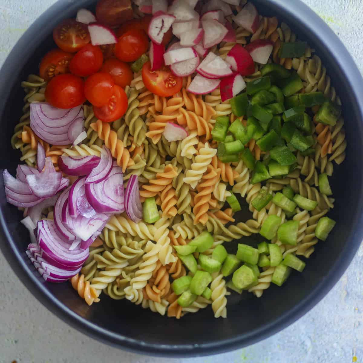 Top the pasta with veggies in a salad bowl.