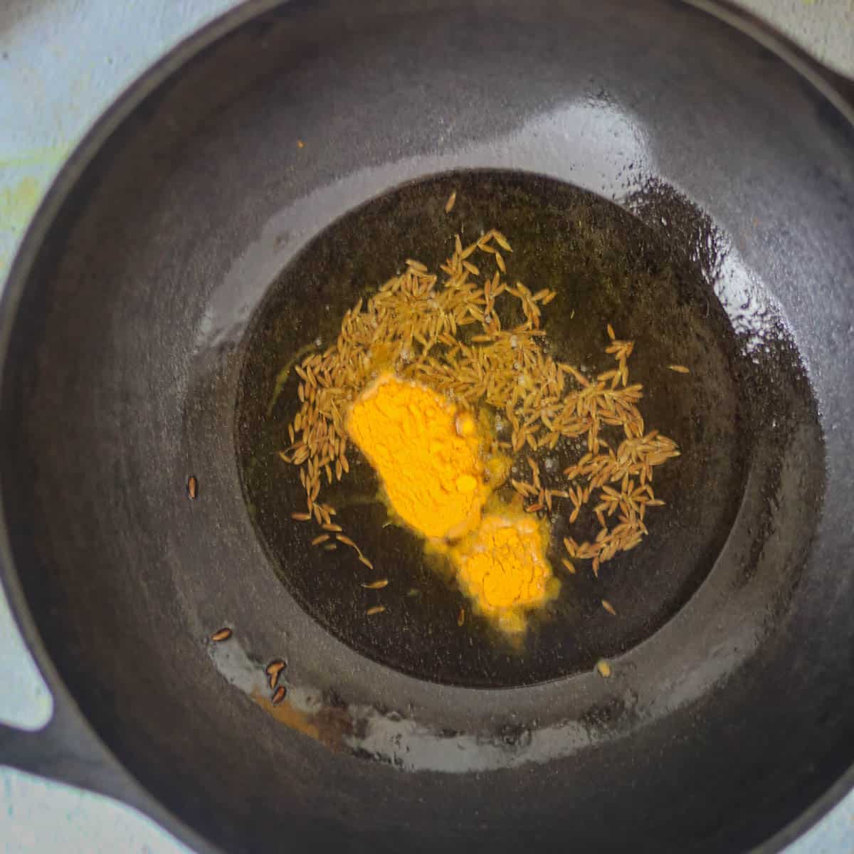 When cumin seeds splutter, add turmeric powder.