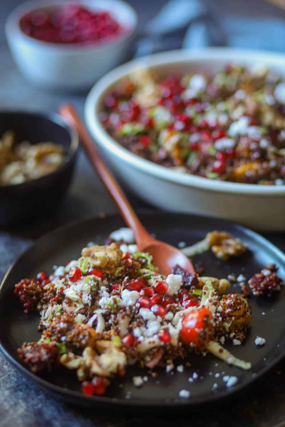 Pumpkin quinoa salad served on a black plate.
