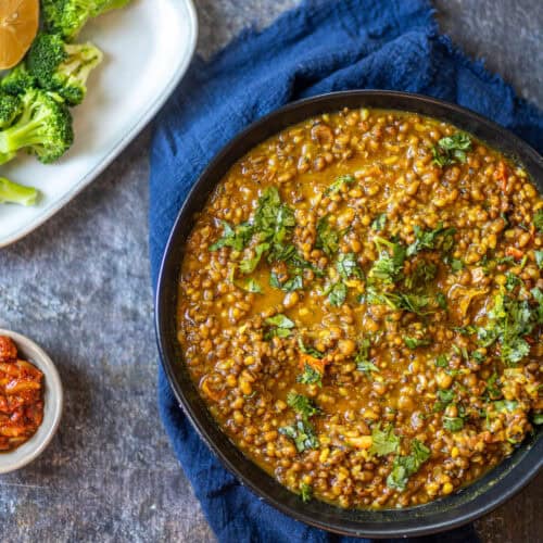 Overshot of green moong dal on a blue background.