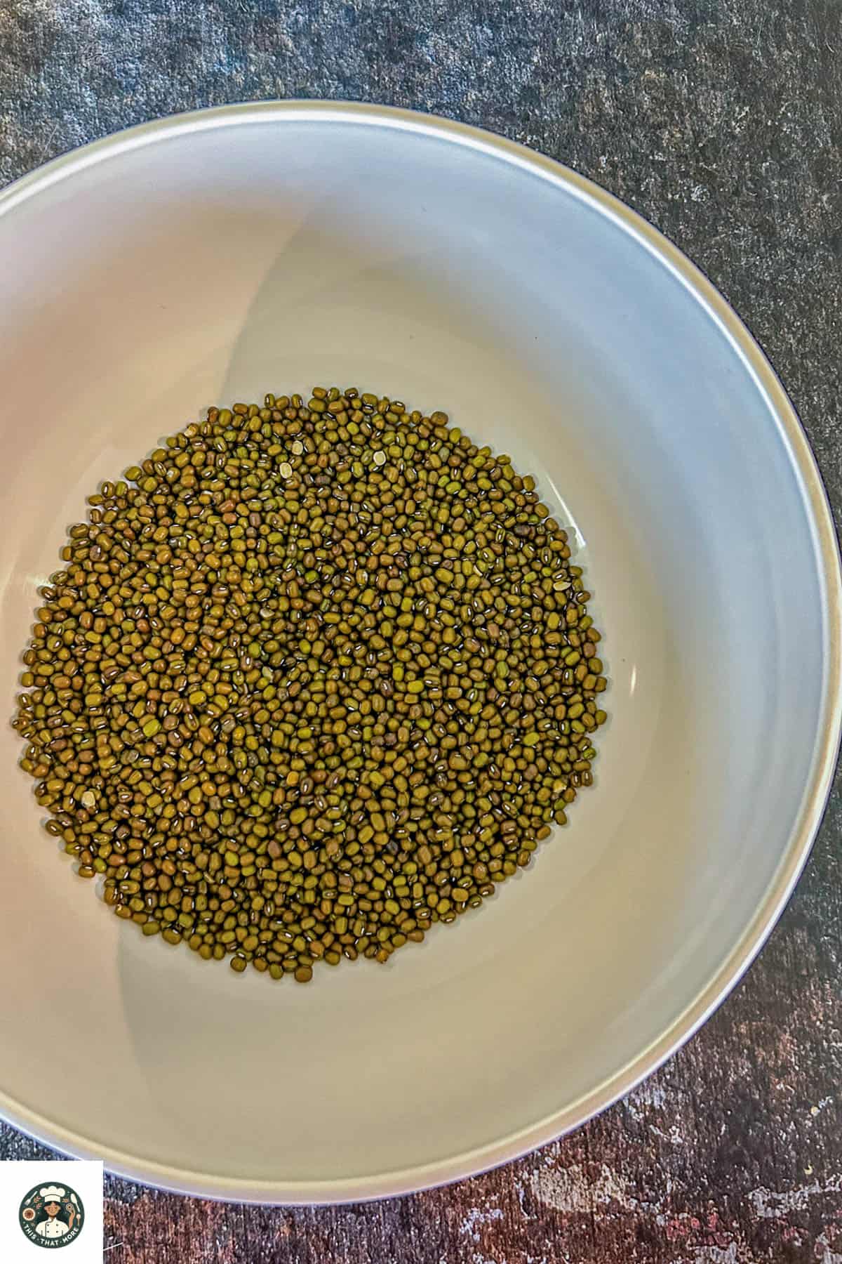 Overhead shot of rinsed green lentils in a white bowl.
