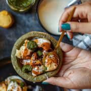 Overshot of dahi bhalla in a small green bowl made form leaves.