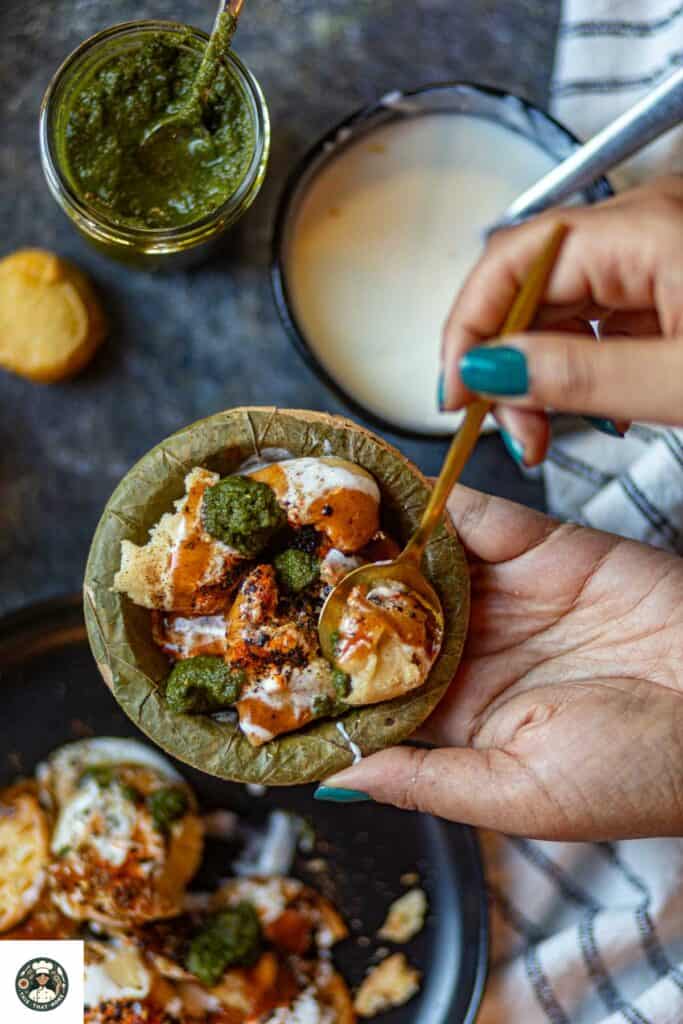 Overshot of dahi bhalla in a small green bowl made form leaves.