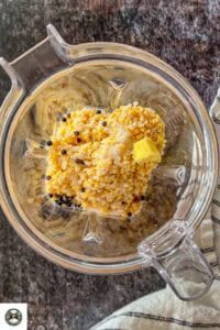 Image showing soakedf lentils added to blender alongwith ginger, salt, and black peppercorns.
