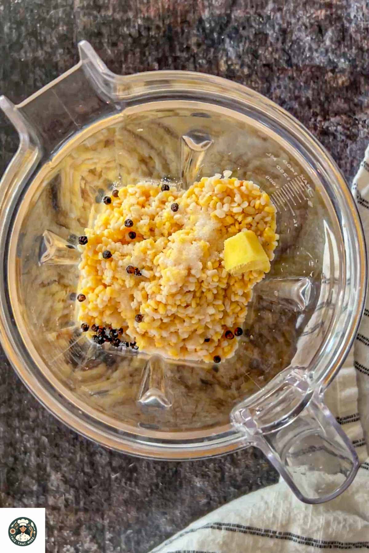 Image showing soakedf lentils added to blender alongwith ginger, salt, and black peppercorns.