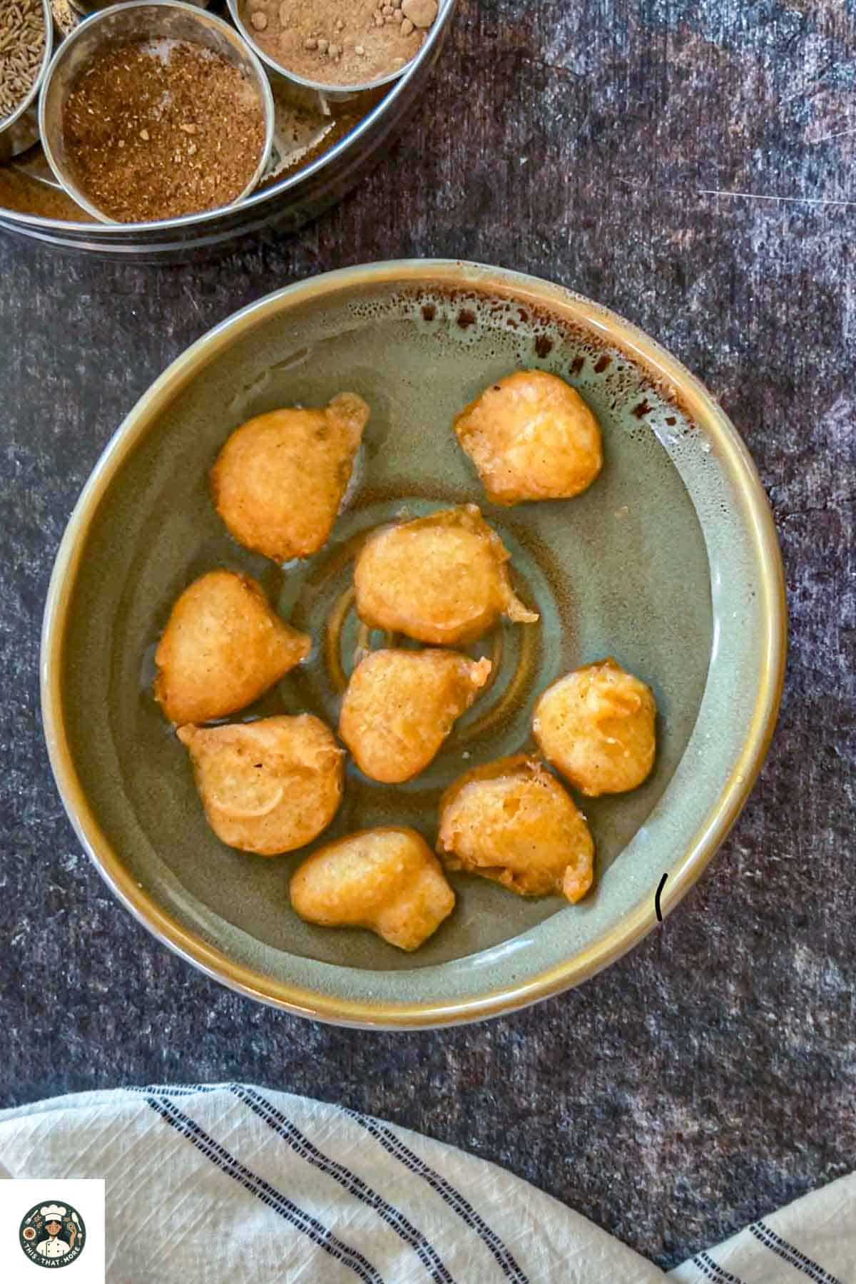 Image showing fried fritters dropped in a bowl filled with water.