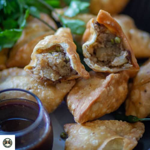 Image of Punjabi samosa with one open samosa.