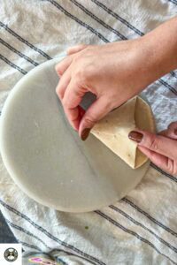 Rub water around the edges. Bring the corners together on the flat side until it form a triangle and seal it.