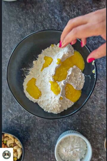 Image showing all purpose flour and ghee in a black bowl.
