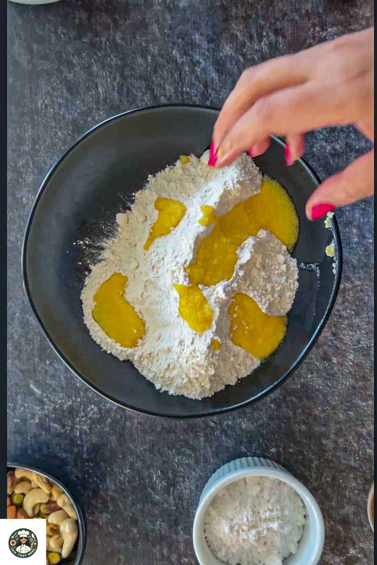 Image showing all purpose flour and ghee in a black bowl.