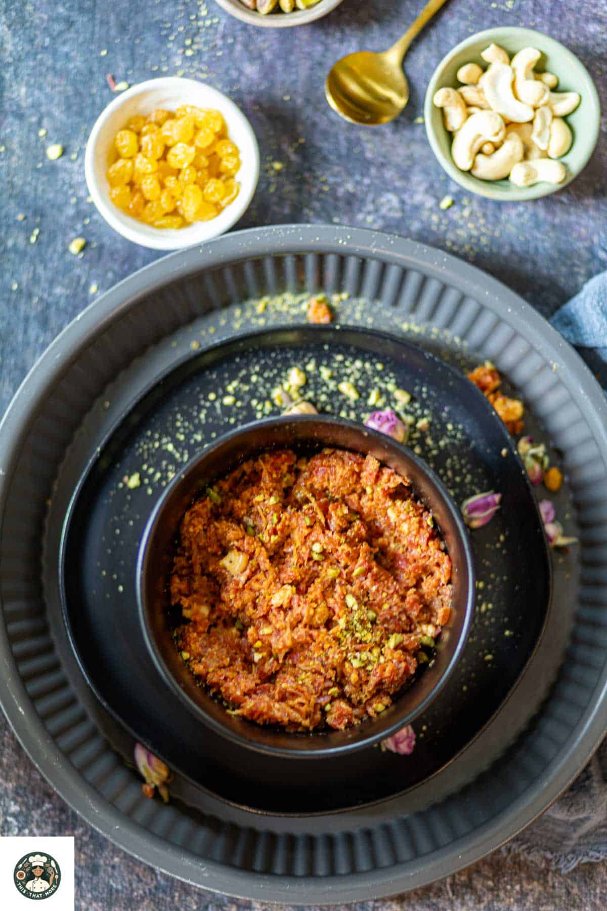 Overshot of Carrot halwa with khoya in a black bowl served with fried nuts.