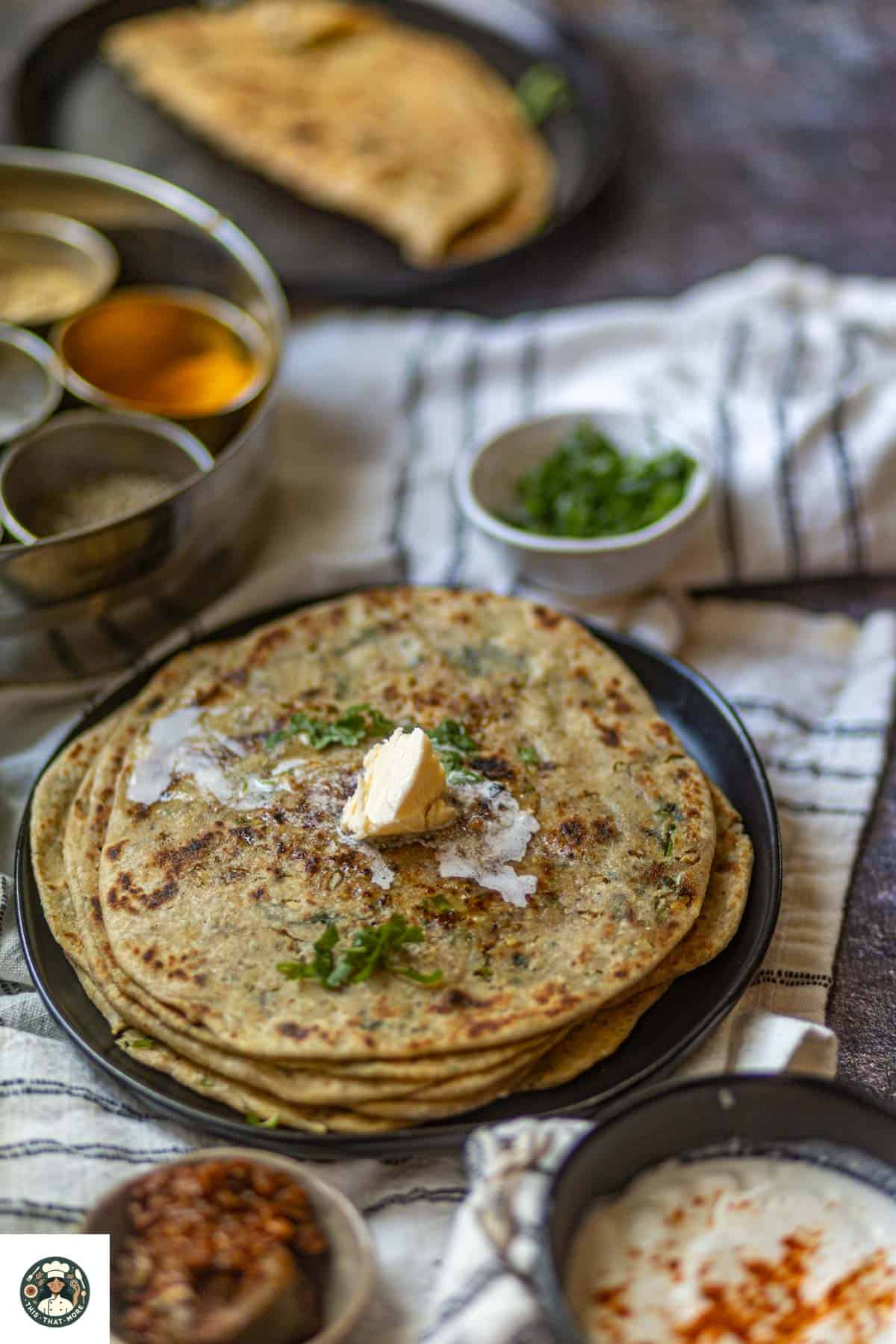 Image showing dollop of butter on stack of gobi parathas.