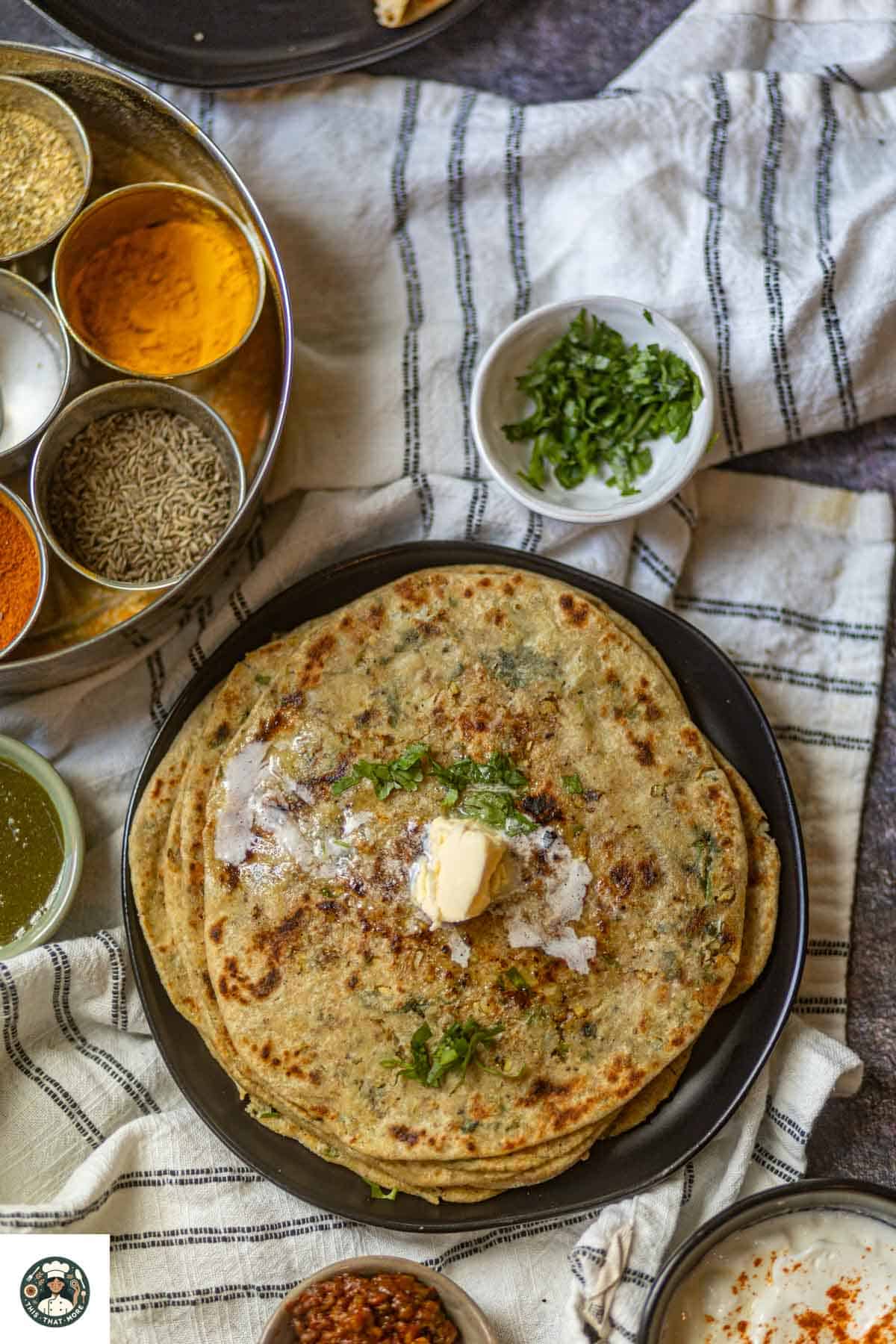 Top shot of Recipe of gobi Paratha placed on a black plate.