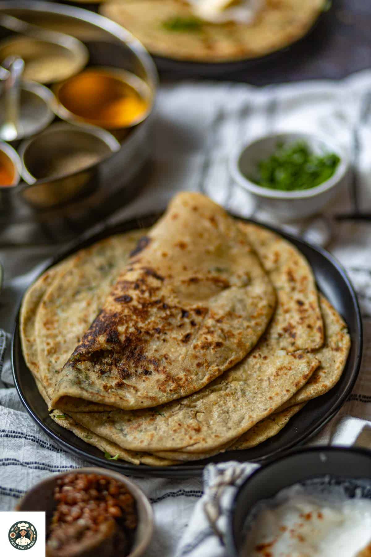 Image showing rolled gobi paratha over stack of parathas.
