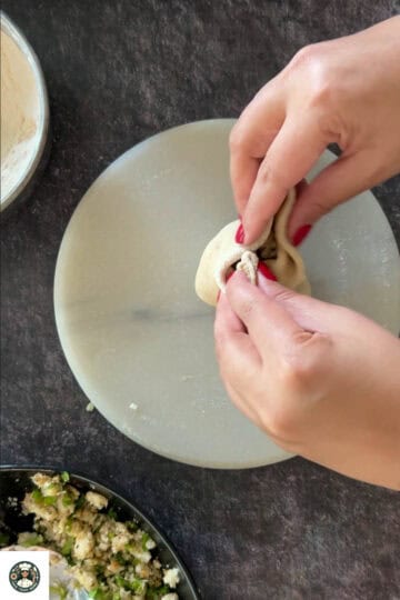Bring the edges together and seal tightly at the top. Flatten gently and roll again into a 6–7 inch paratha. Use dry flour if it sticks.