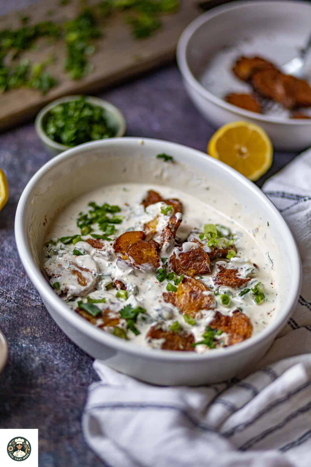 Smashed potato salad served in a white bowl.