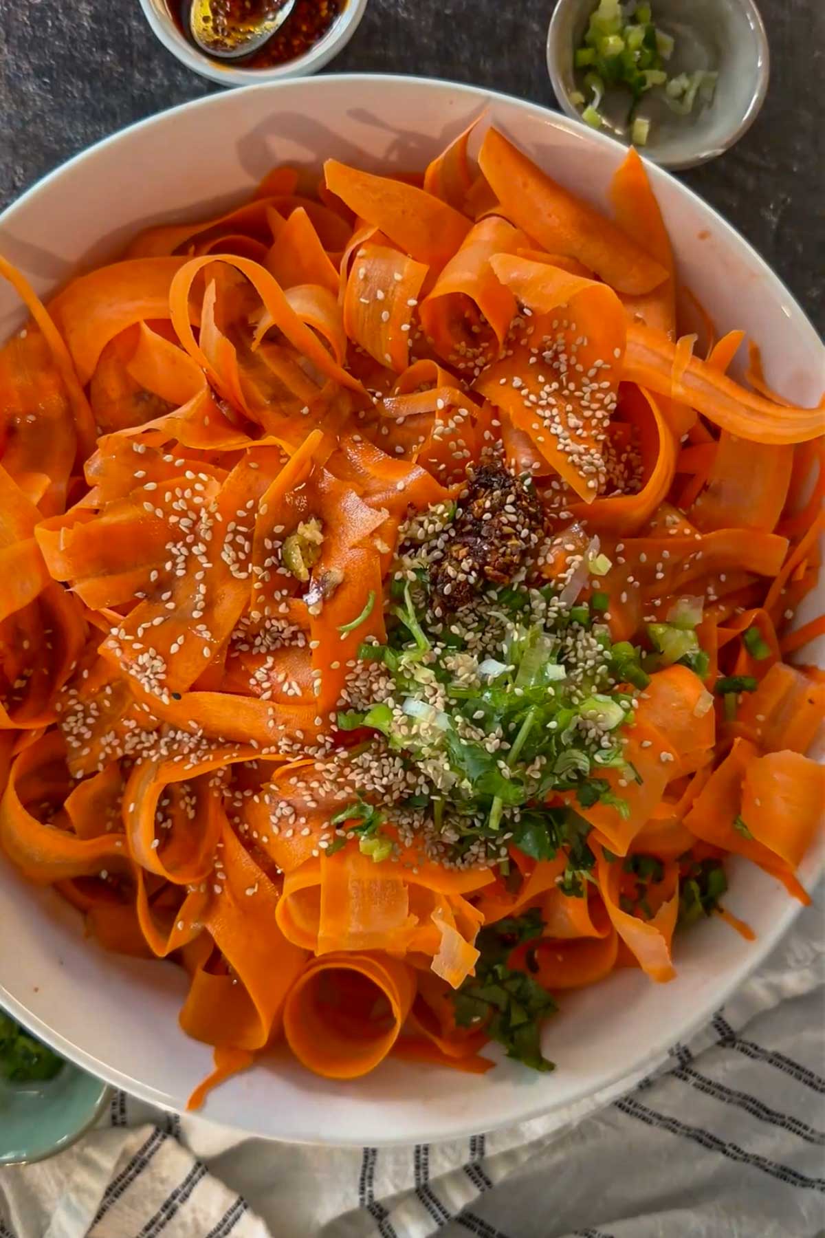 Sesame seeds, herbs, and seasoning added to carrot ribbons.