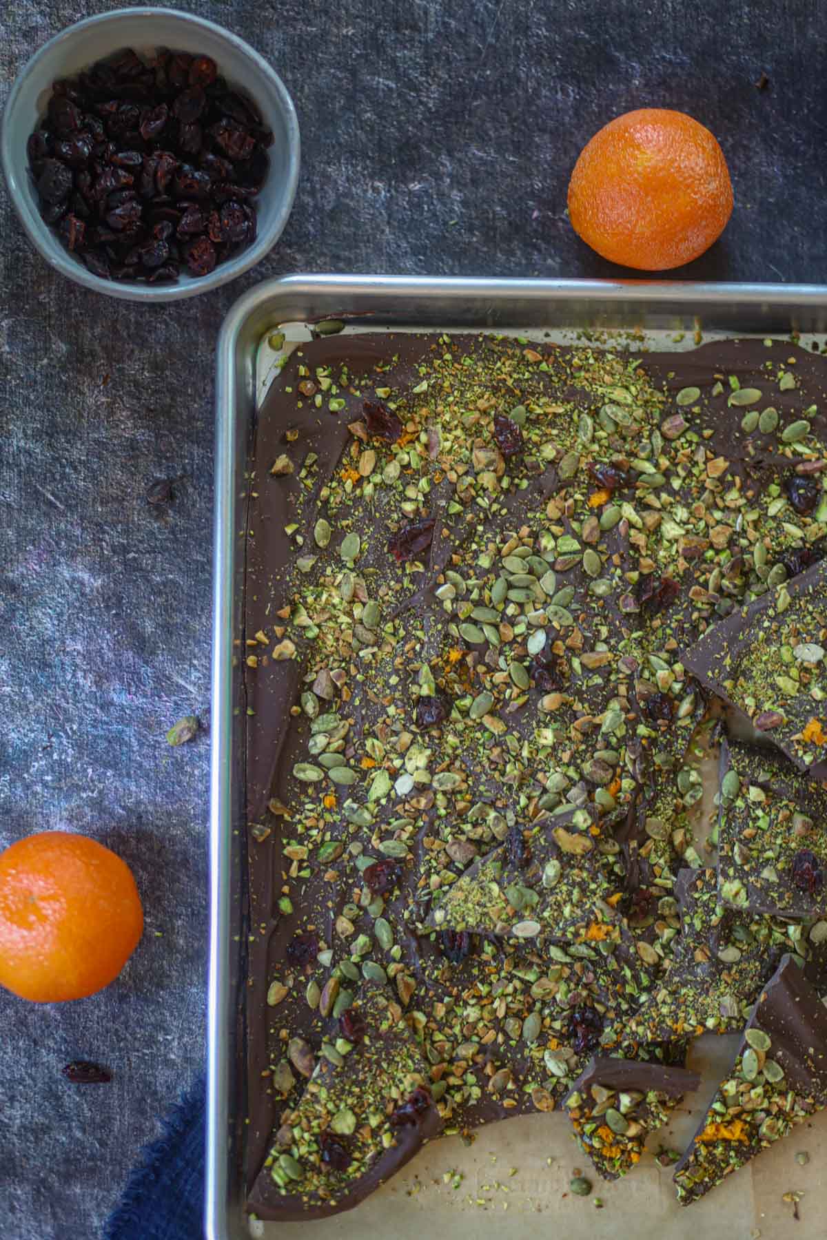 Overhead view of pistachio cranberry chocolate bark with orange zest and dried cranberries.
