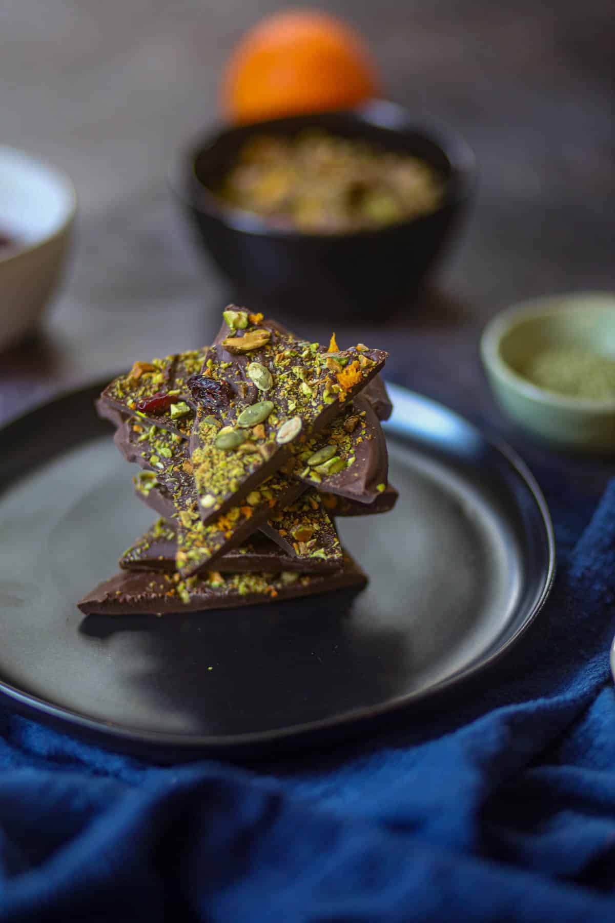 Stacked pieces of pistachio cranberry chocolate bark served on a plate.