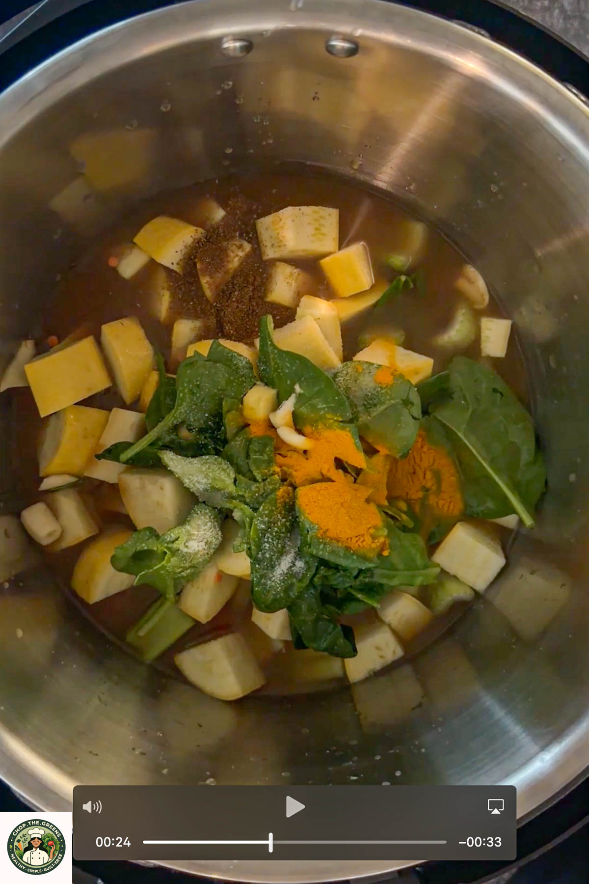 Uncooked lentil soup ingredients including squash and spinach in a pot.