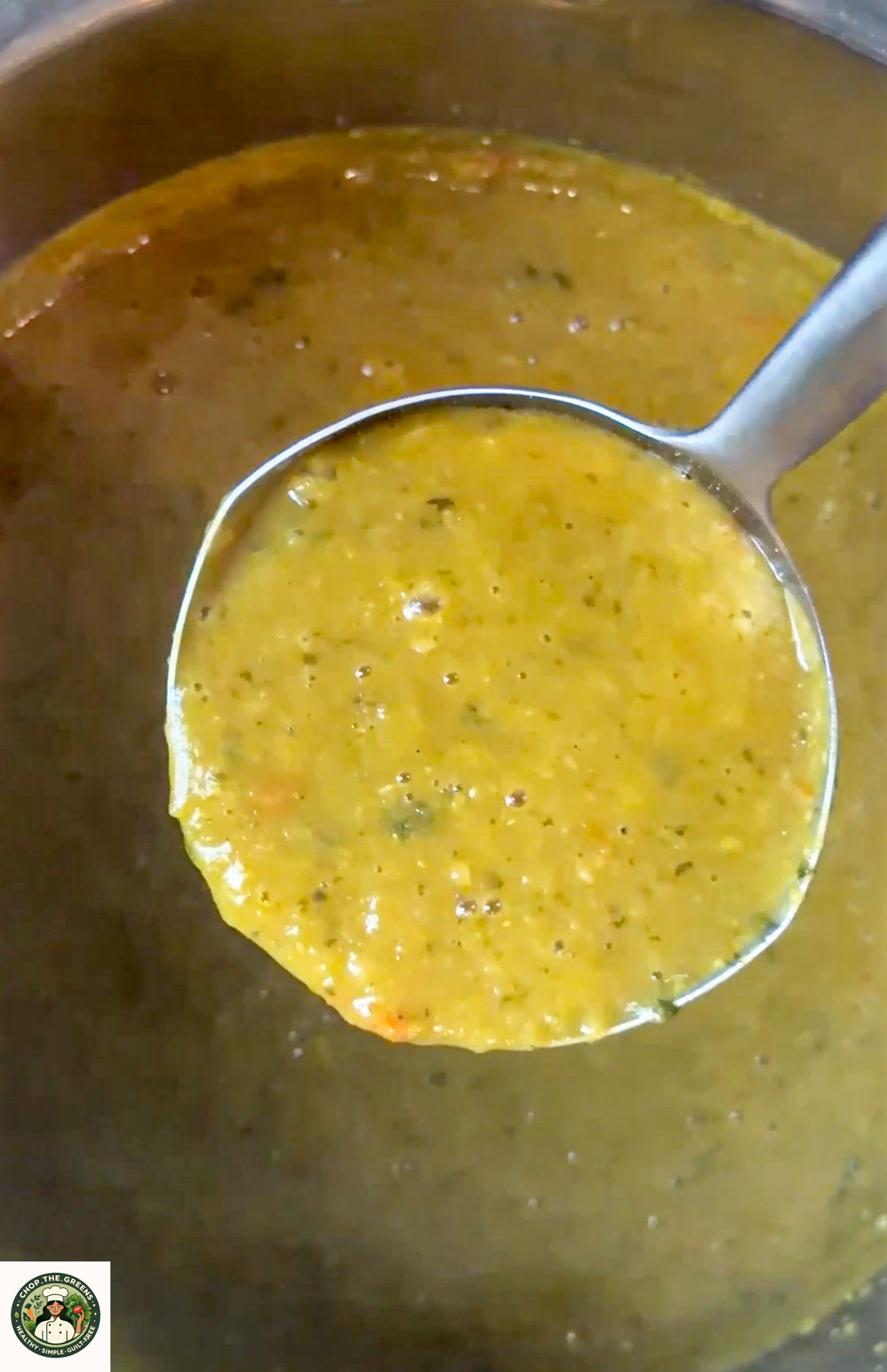 Ladle holding creamy yellow lentil soup over a pot