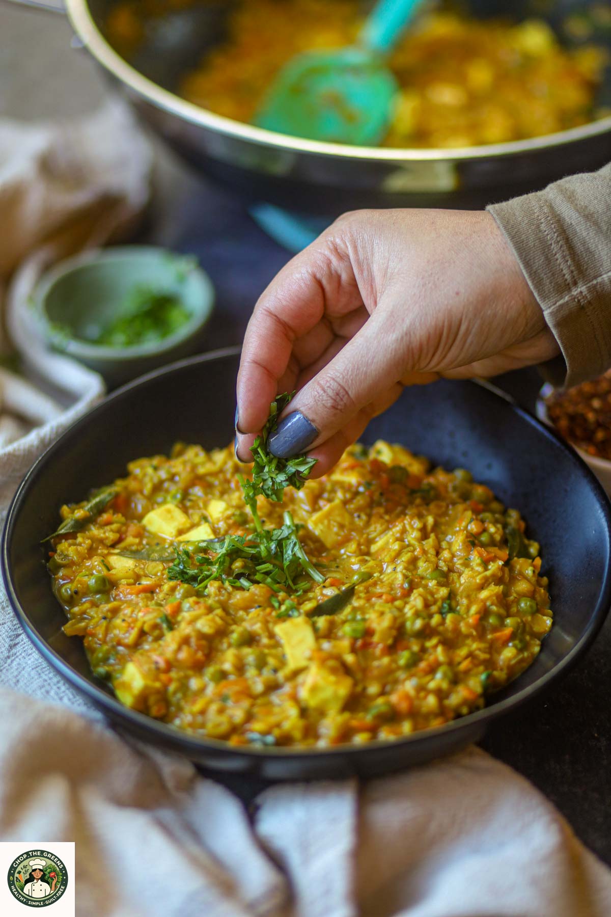 Garnishing masala oats with fresh cilantro.