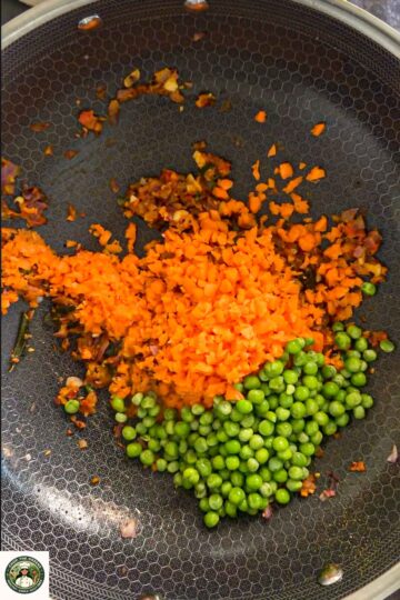 Carrots and green peas added to sautéed onions for masala oats.