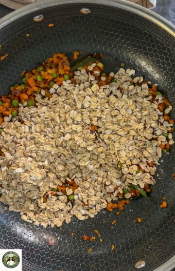 Rolled oats added to vegetables while making masala oats.