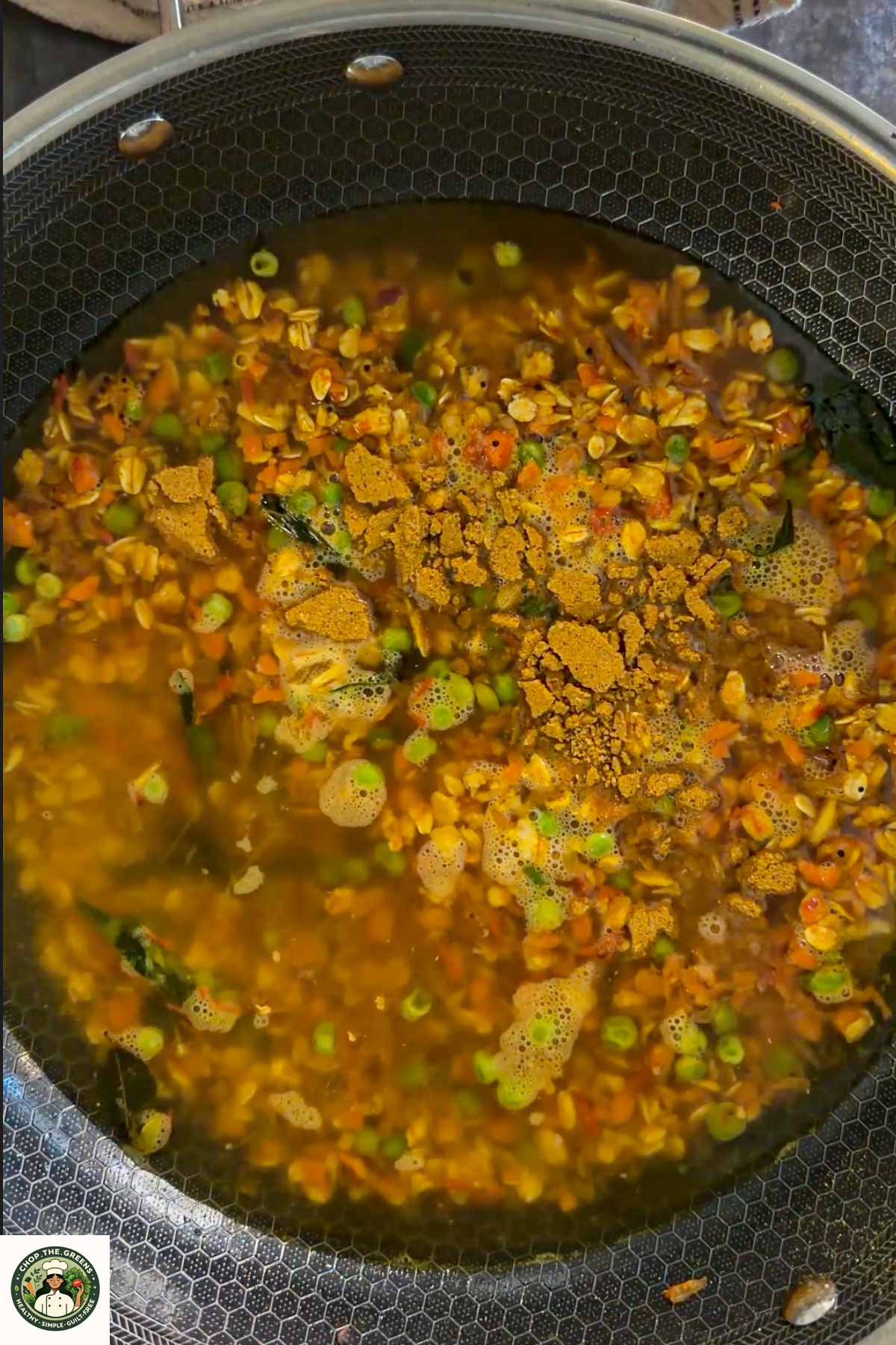 Water and spices added to oats and vegetables for masala oats.