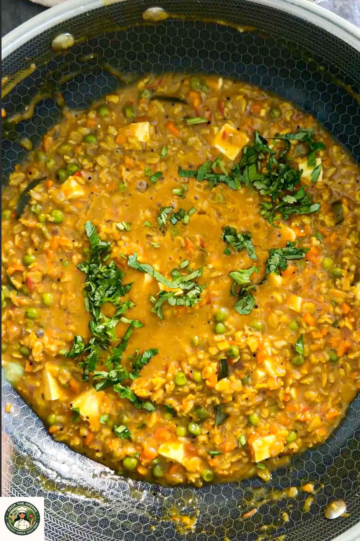 Finished masala oats garnished with herbs in a bowl.
