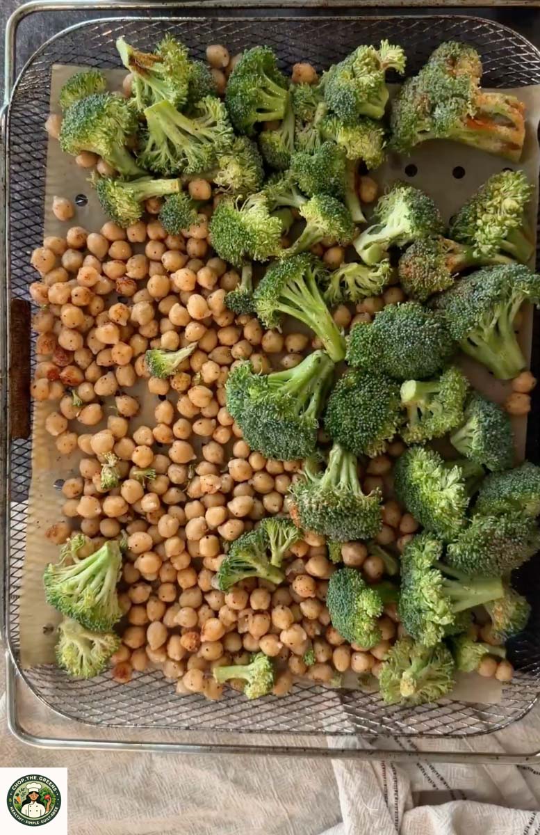 Seasoned broccoli and chickpeas placed in air fryer basket.
