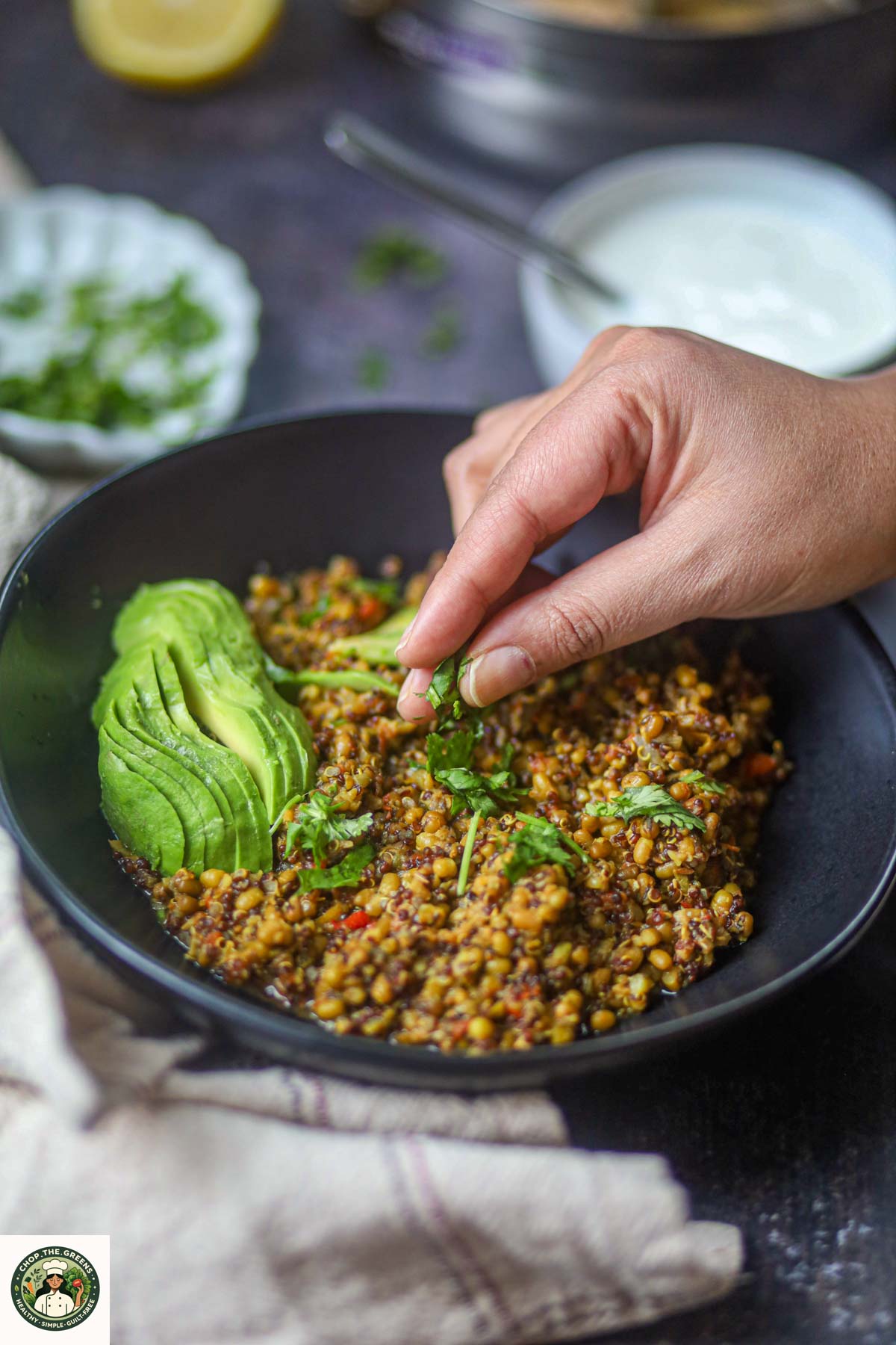Garnishing Instant Pot lentil quinoa bowl with fresh cilantro.