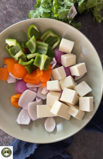 Paneer cubes with bell peppers and onions for hariyali paneer tikka.
