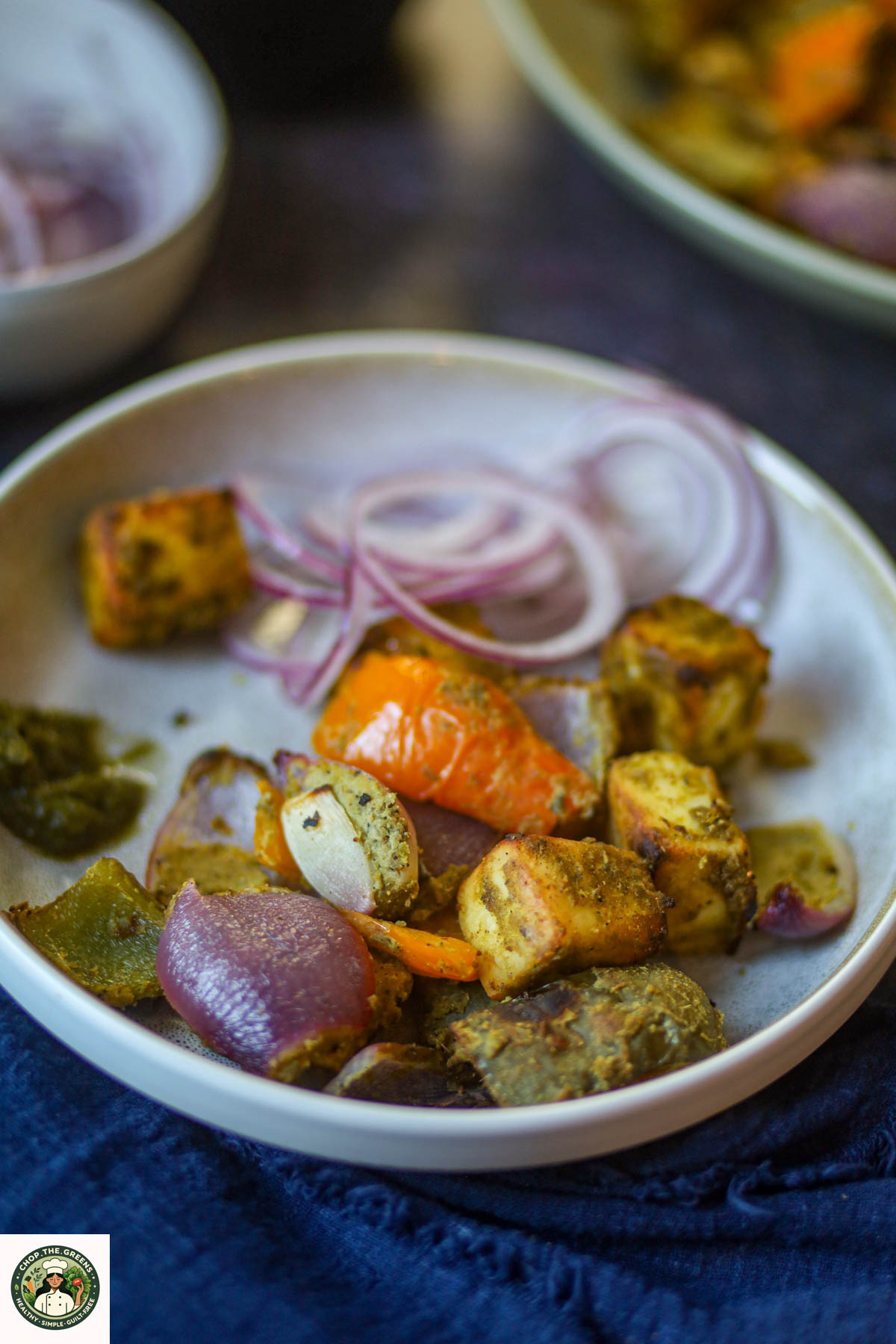 Hariyali paneer tikka with onions and bell peppers served in a bowl.