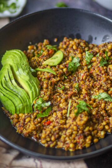Instant Pot lentil and quinoa protein bowl topped with avocado and herbs