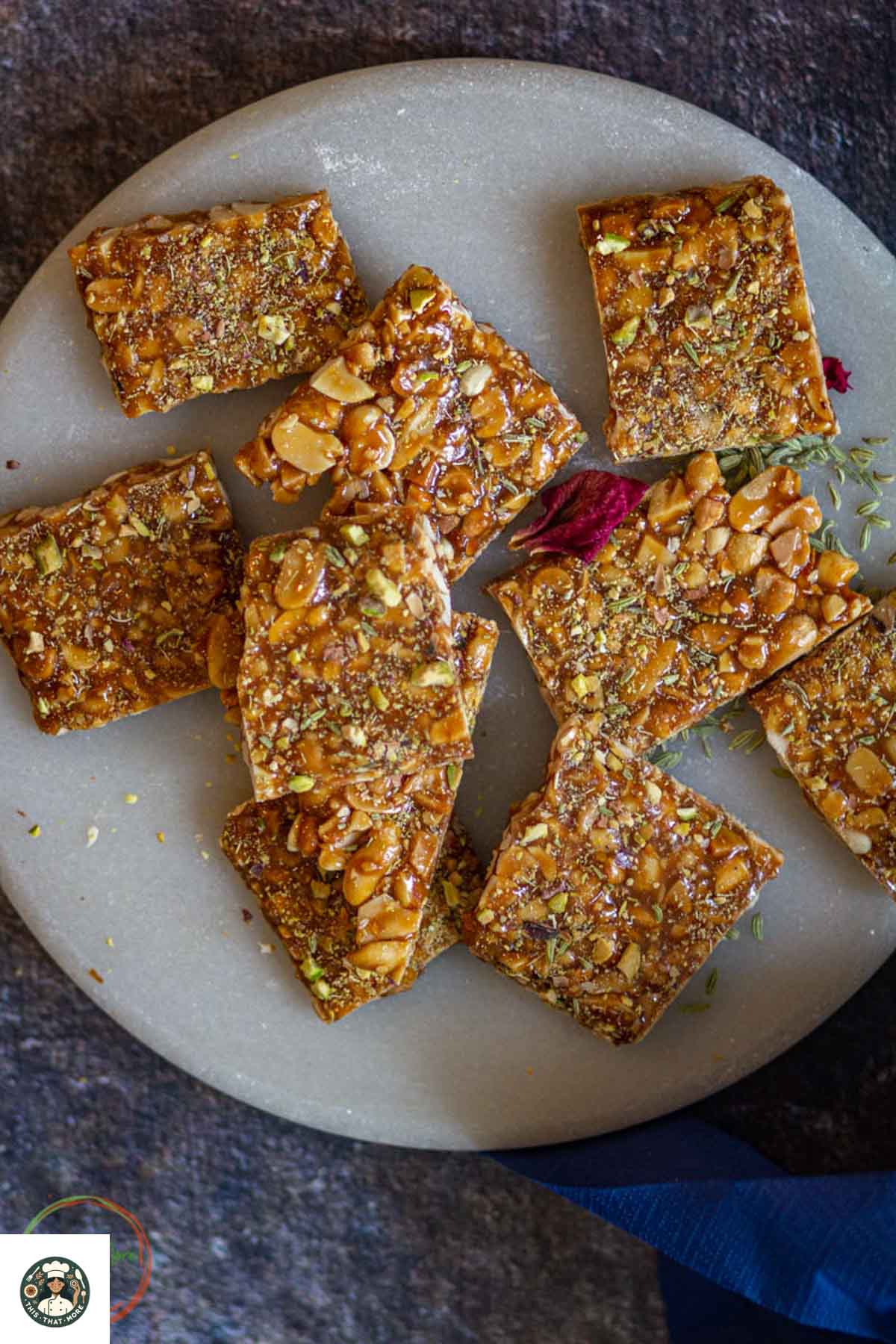 Peanut chikki squares served on a plate with pistachio garnish.