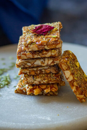 Stacked peanut chikki squares made with jaggery and roasted peanuts.