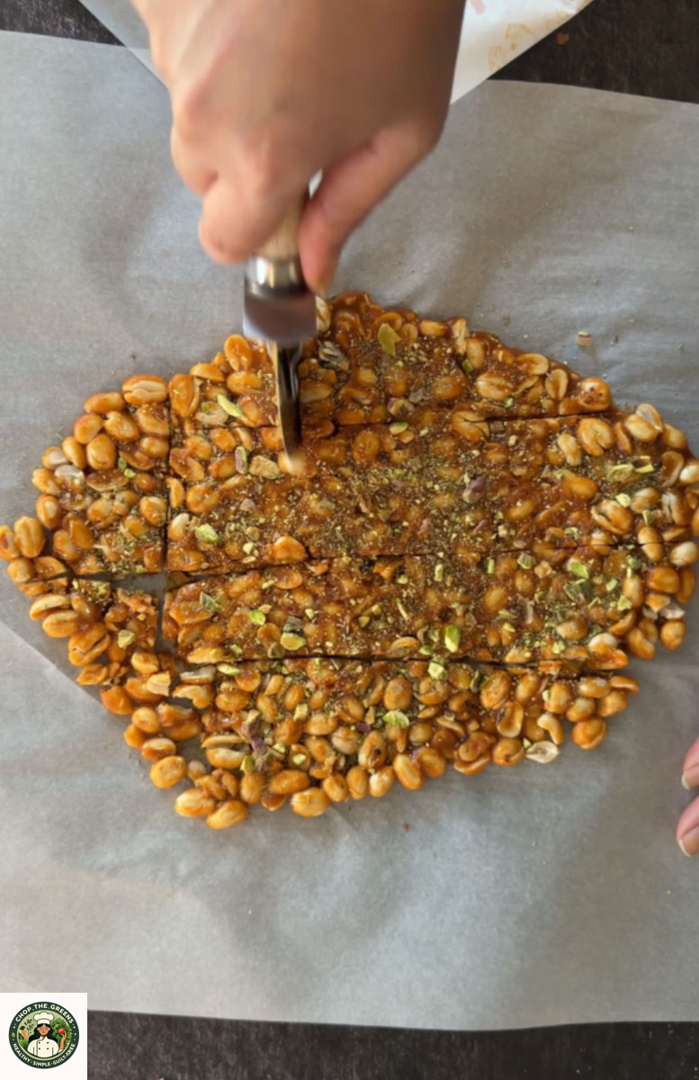 Cutting peanut gajak into squares while warm.