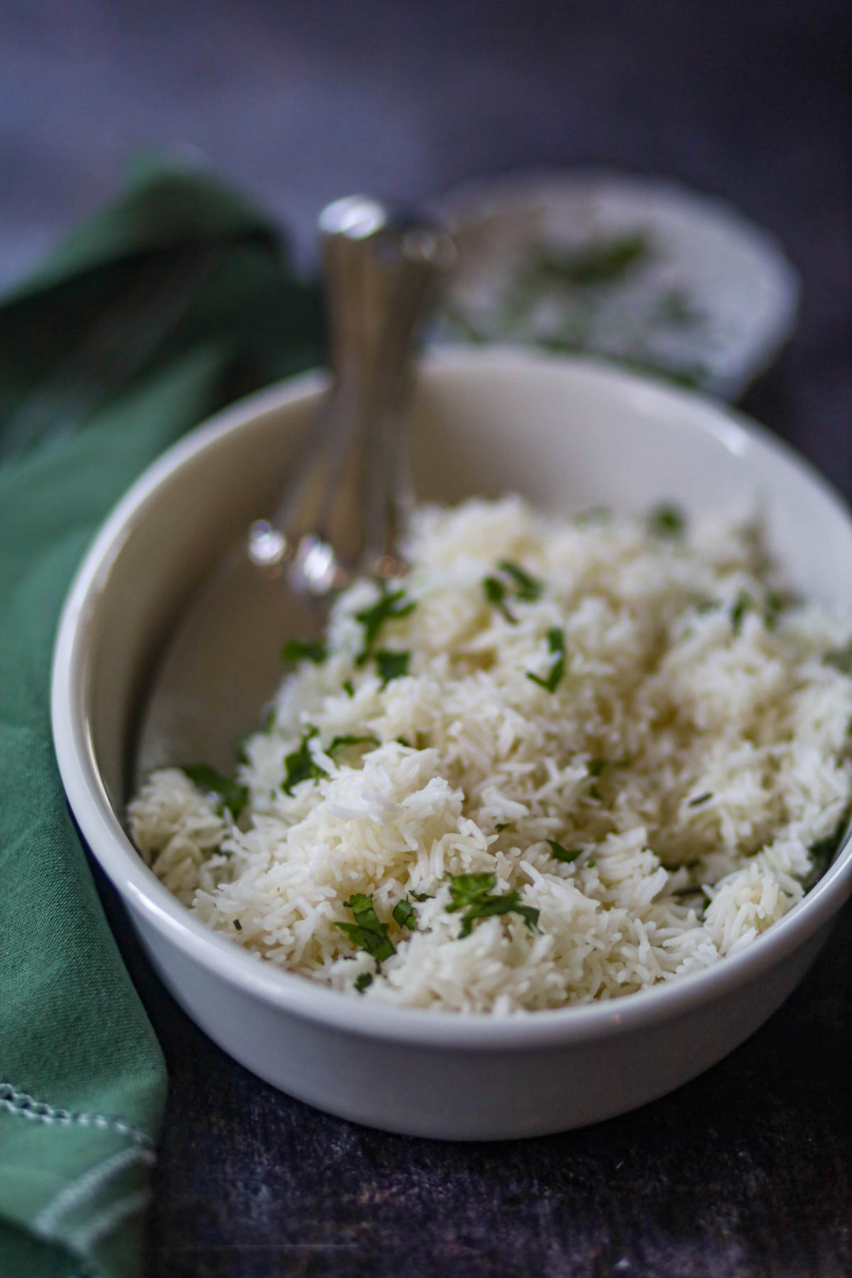 Basmati rice garnished with fresh cilantro in a white bowl.