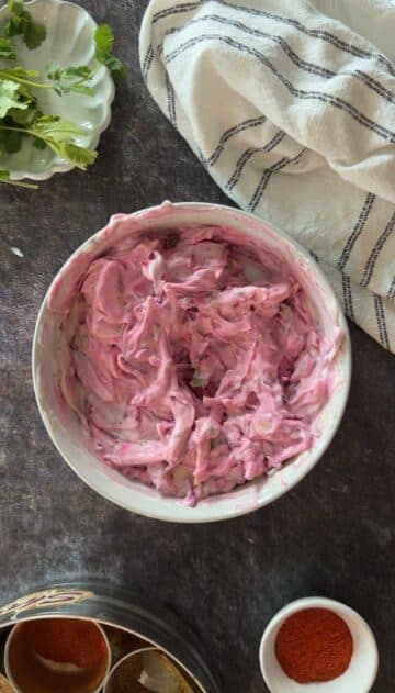Creamy beetroot raita mixed in bowl.