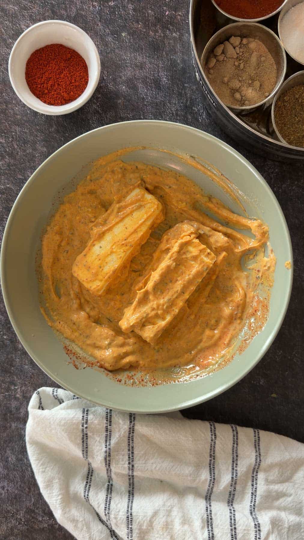 Paneer cubes coated in tikka marinade before grilling.