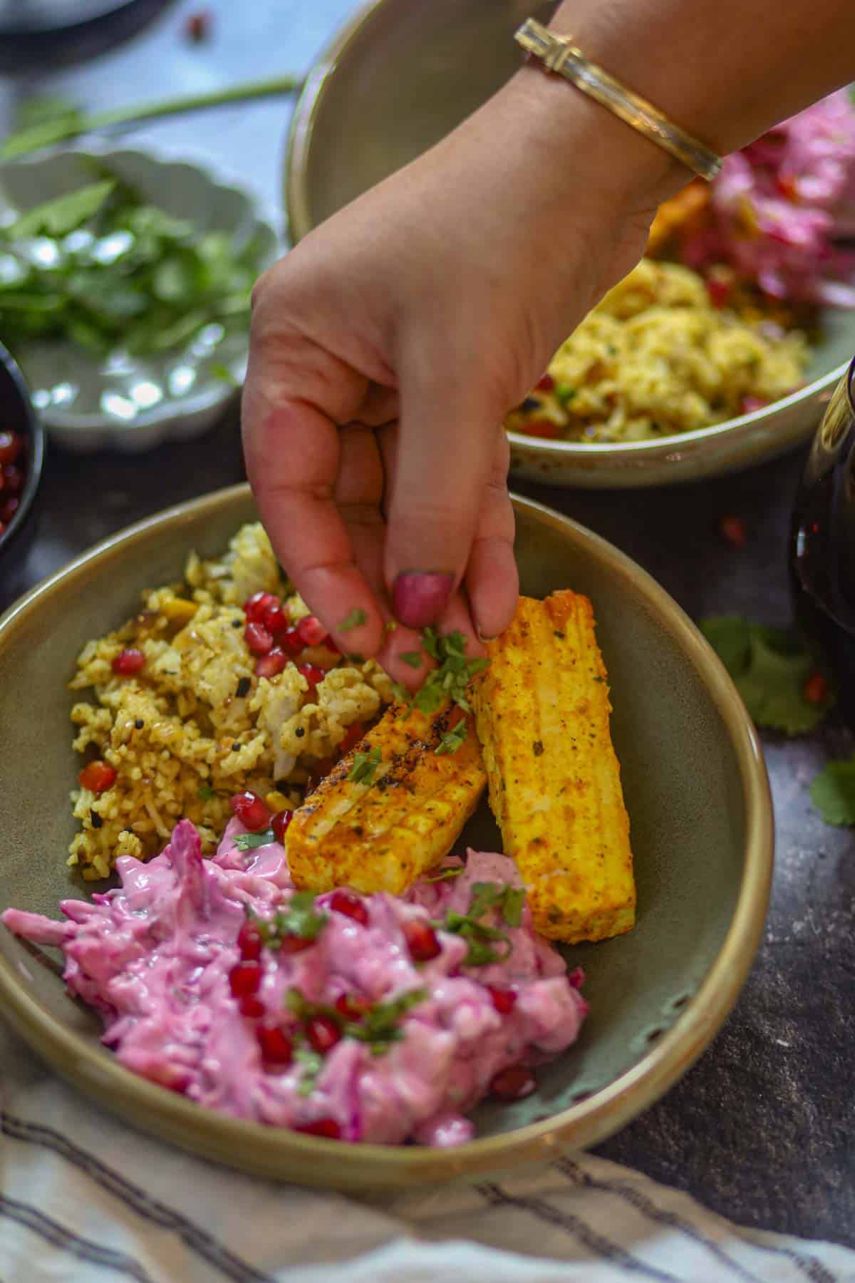 Garnishing paneer tikka bowl with fresh herbs for date night.