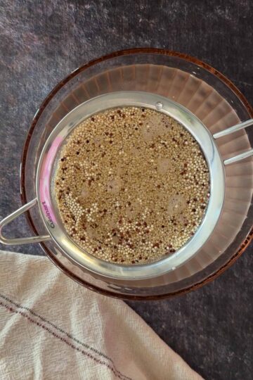 Rinsing quinoa in strainer to remove saponin before Instant Pot cooking.