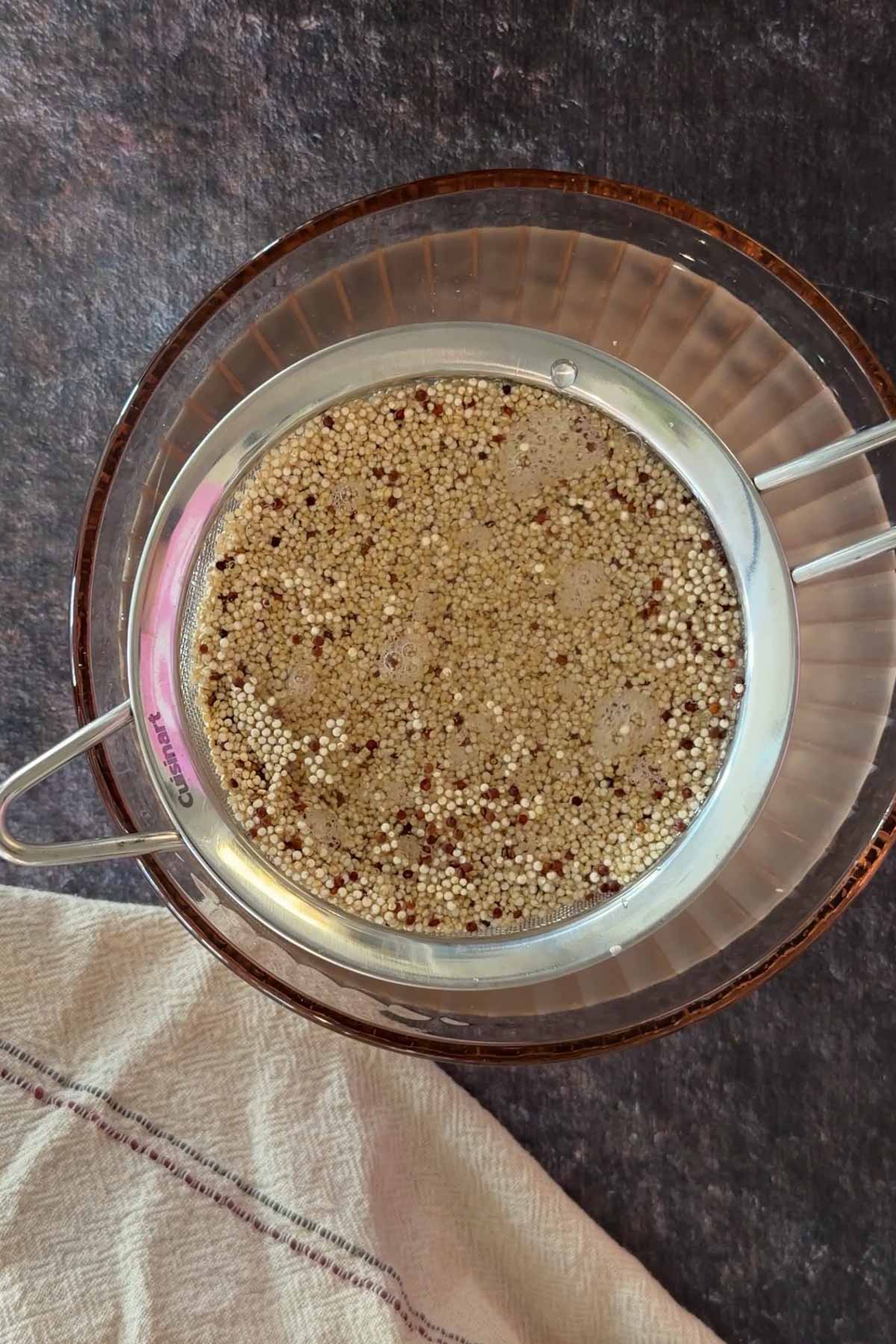 Rinsing quinoa in strainer to remove saponin before Instant Pot cooking.