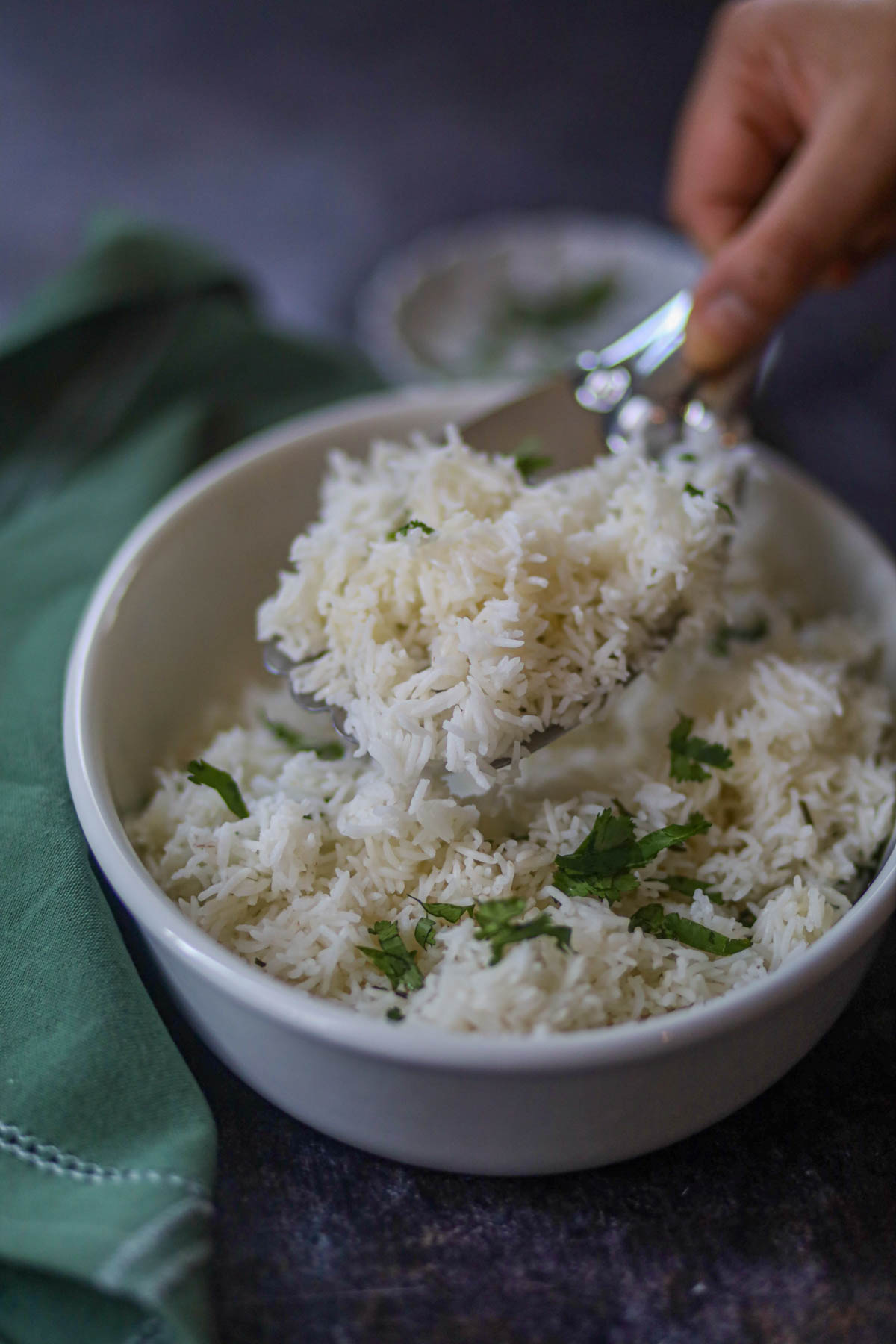 Spoon lifting fluffy basmati rice from bowl.