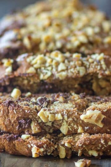 Healthy banana bread loaf topped with chopped nuts and chocolate chips.